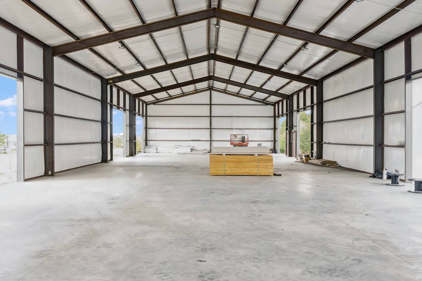 Inside an empty Melissa bay: steel frame, open roll-up doors at both ends and a concrete floor